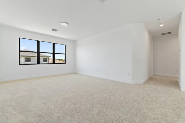 an empty room with windows and cabinet