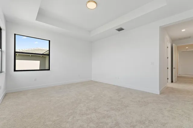 an empty room with windows and cabinet