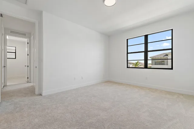 an empty room with windows and ceiling fan