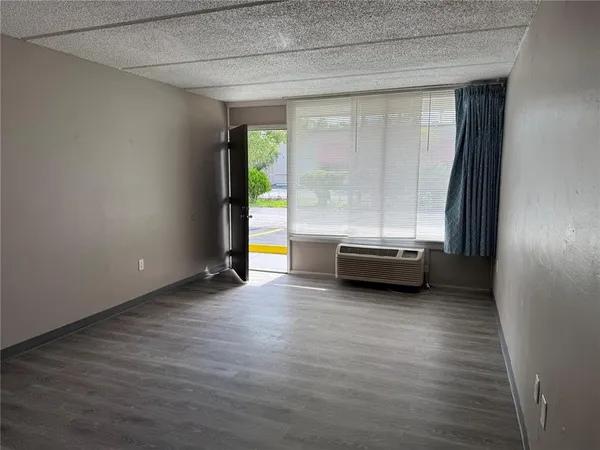 a view of a room with wooden floor and a window