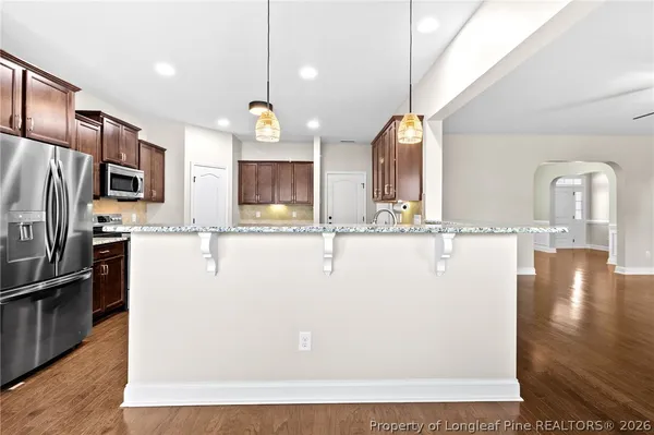 a view of a kitchen with kitchen island a counter top space appliances and cabinets