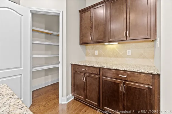 a view of a storage and utility room with wooden floor