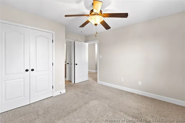an empty room with chandelier fan