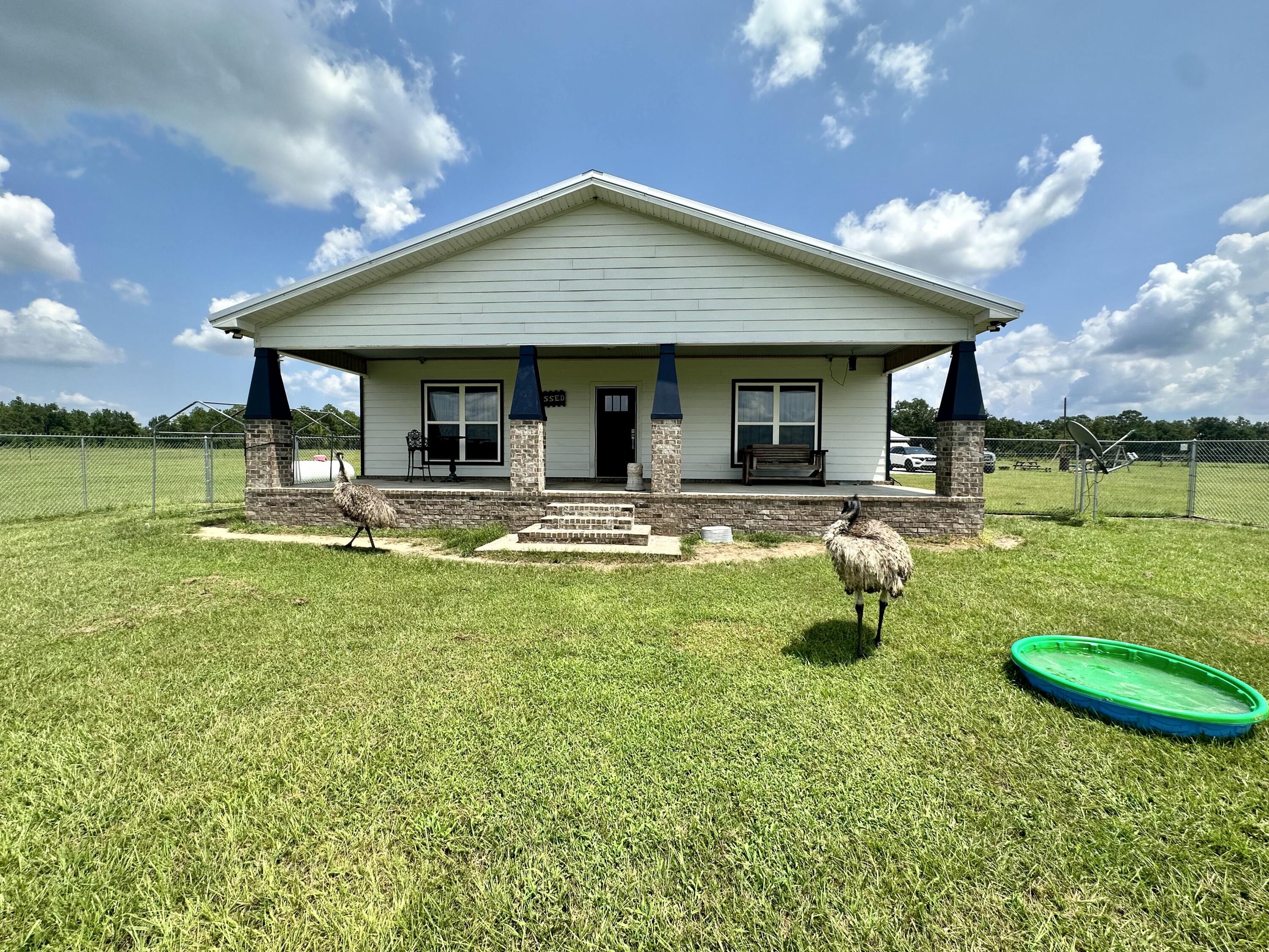 5170 Poplar Head Church Road Holt, FL 32564 - Photo 2 of 35 a front view of a house with swimming pool and a yard