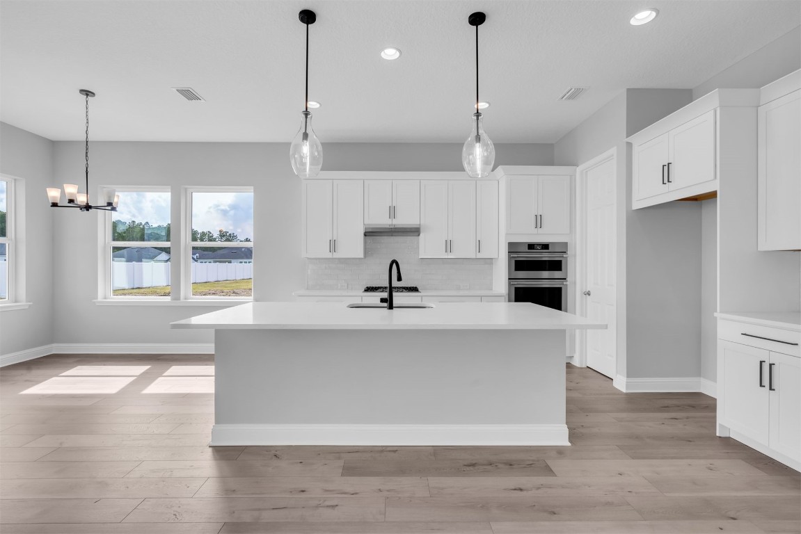 454 Slash Pine Place Yulee, FL 32097 - Photo 12 of 34 a view of a kitchen with kitchen island a sink stainless steel appliances and cabinets