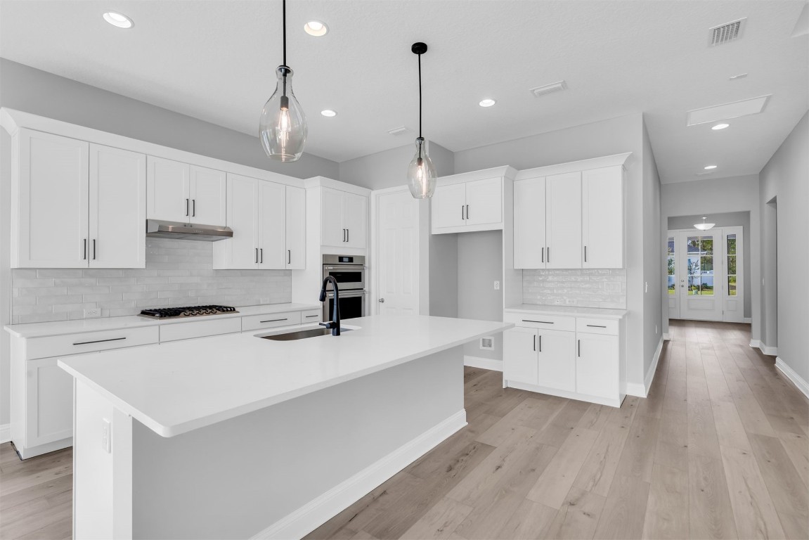 454 Slash Pine Place Yulee, FL 32097 - Photo 16 of 34 a kitchen with white cabinets and stainless steel appliances