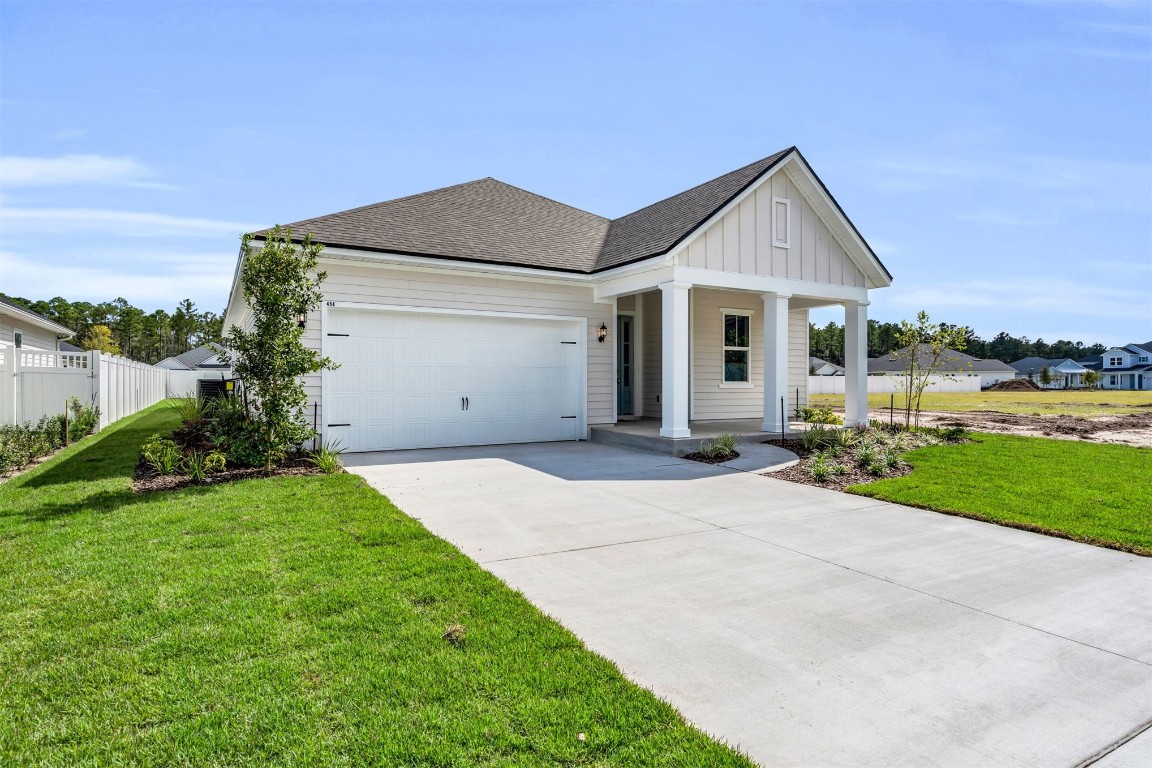 454 Slash Pine Place Yulee, FL 32097 - Photo 3 of 34 a front view of a house with a yard and garage