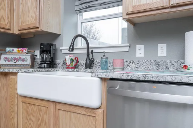 a kitchen with granite countertop a sink stainless steel appliances and cabinets