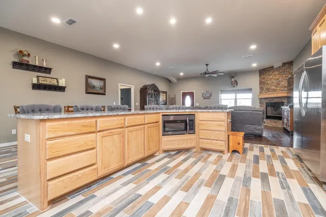 a large kitchen with stainless steel appliances kitchen island granite countertop a sink and cabinets
