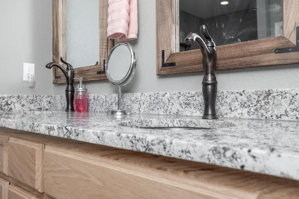 a bathroom with a granite countertop sink and a mirror