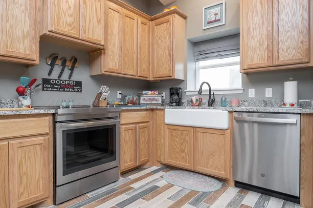a kitchen with cabinets appliances a sink and a window