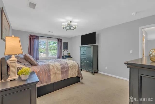a spacious bedroom with a bed and a chandelier