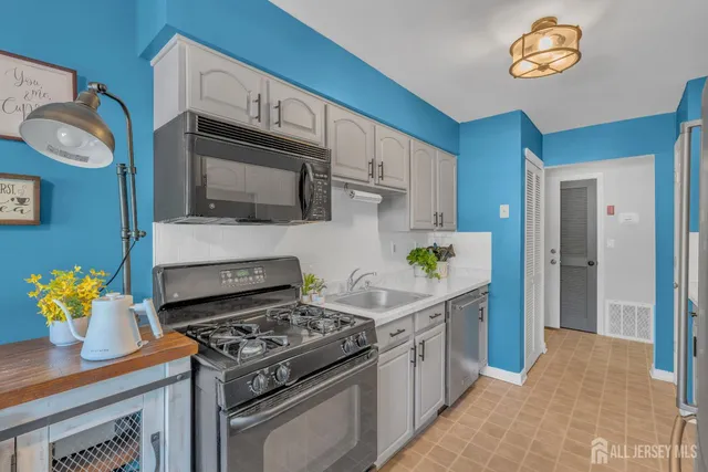 a kitchen with stainless steel appliances granite countertop a stove a sink and a microwave