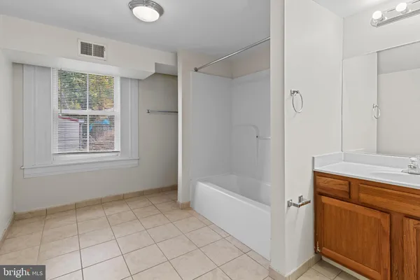 a bathroom with a tub shower and sink
