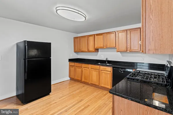 a kitchen with granite countertop a refrigerator stove and sink