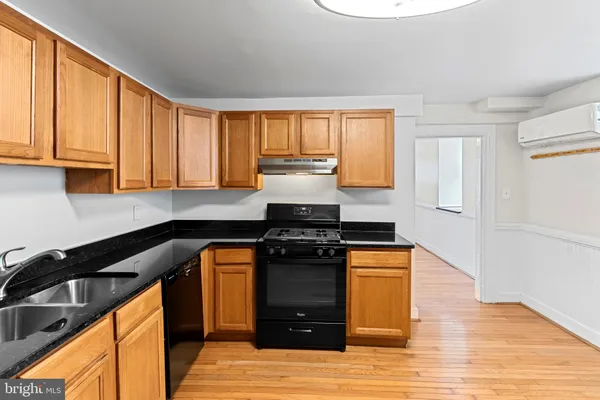 a kitchen with a stove and a wooden floors