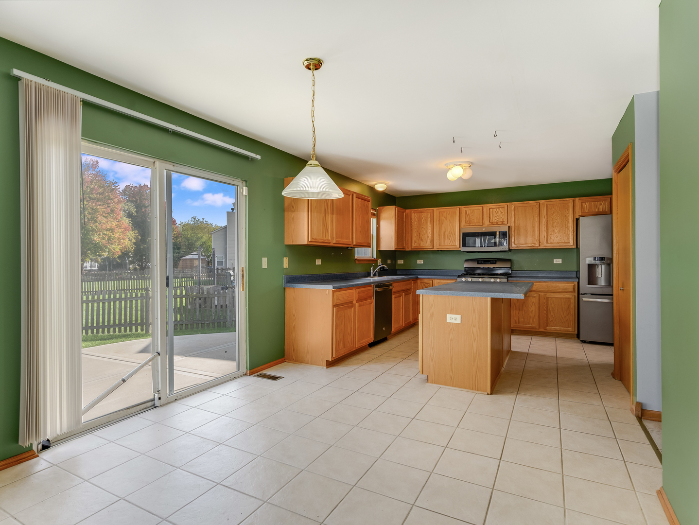 1910 Arbor Fields Drive Plainfield, IL 60586 - Photo 11 of 26 a kitchen with stainless steel appliances kitchen island granite countertop a stove a sink and a refrigerator