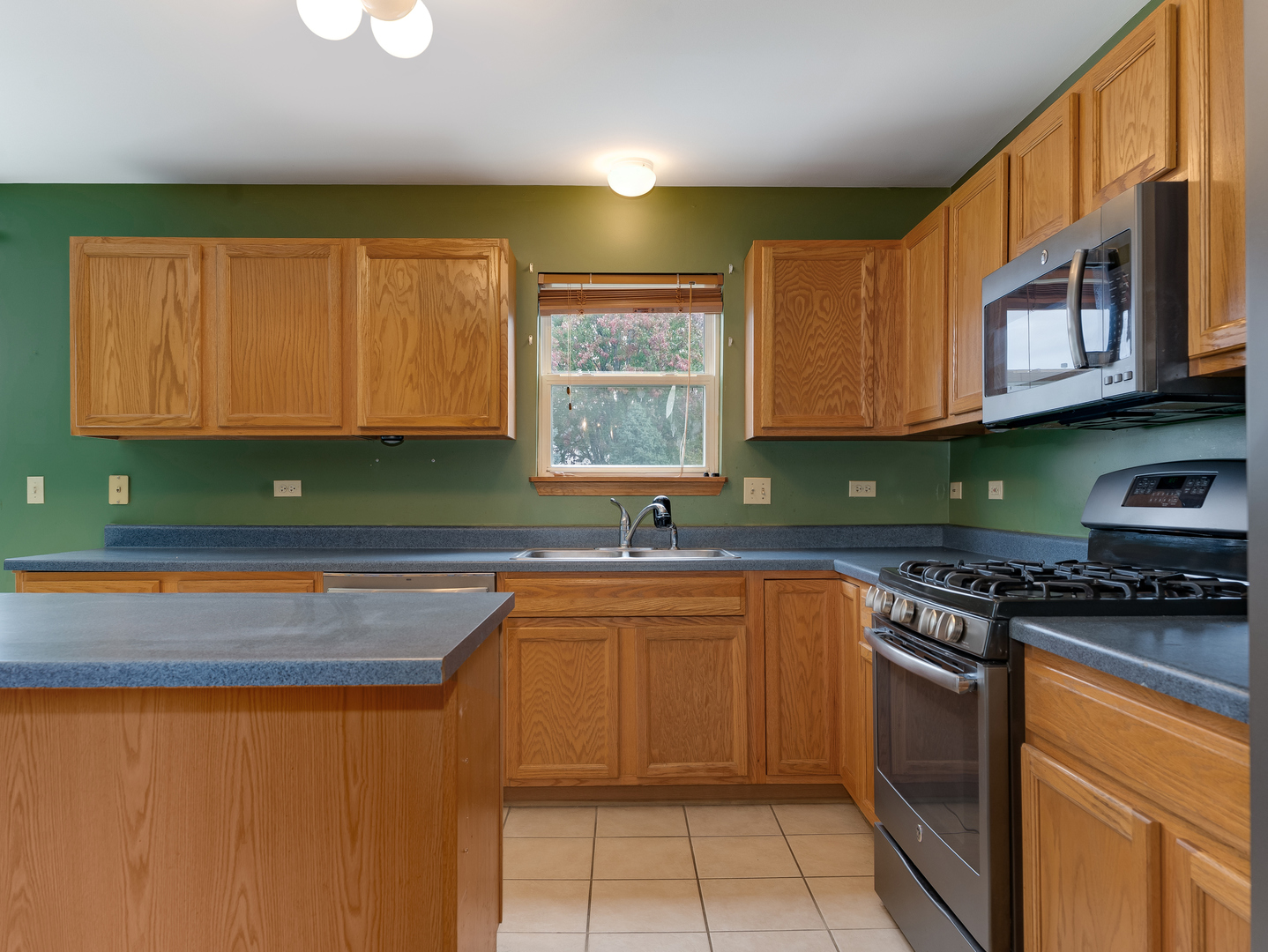1910 Arbor Fields Drive Plainfield, IL 60586 - Photo 10 of 26 a kitchen with stainless steel appliances granite countertop a stove a sink dishwasher and a microwave oven with large cabinets