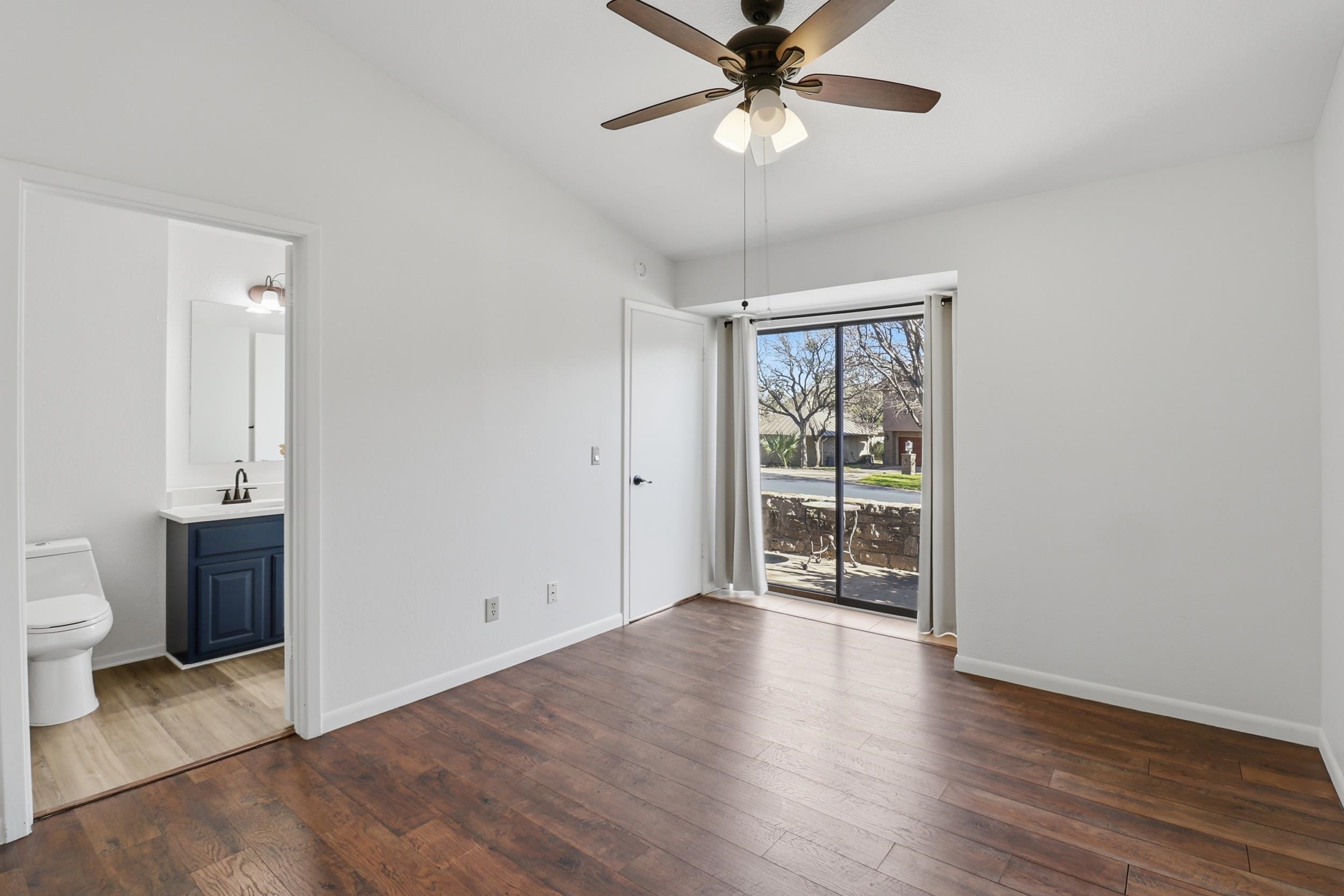100 Bay Point Drive, Unit 3 Horseshoe Bay, TX 78657 - Photo 12 of 26 an empty room with wooden floor fan and windows