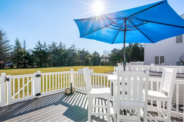 a view of balcony with wooden deck and outdoor seating