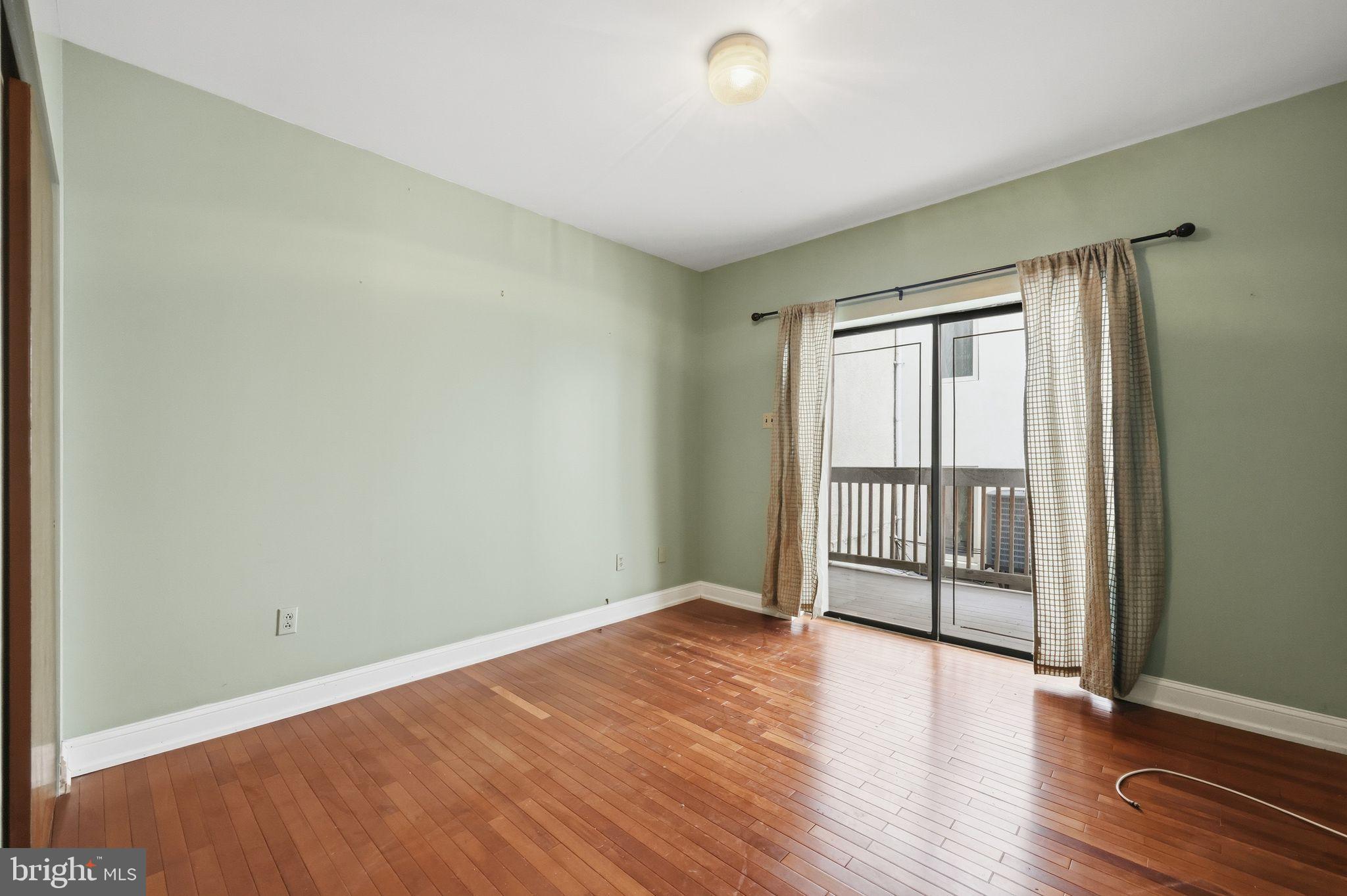1713 South Street Philadelphia, PA 19146 - Photo 17 of 35 an empty room with wooden floor and windows