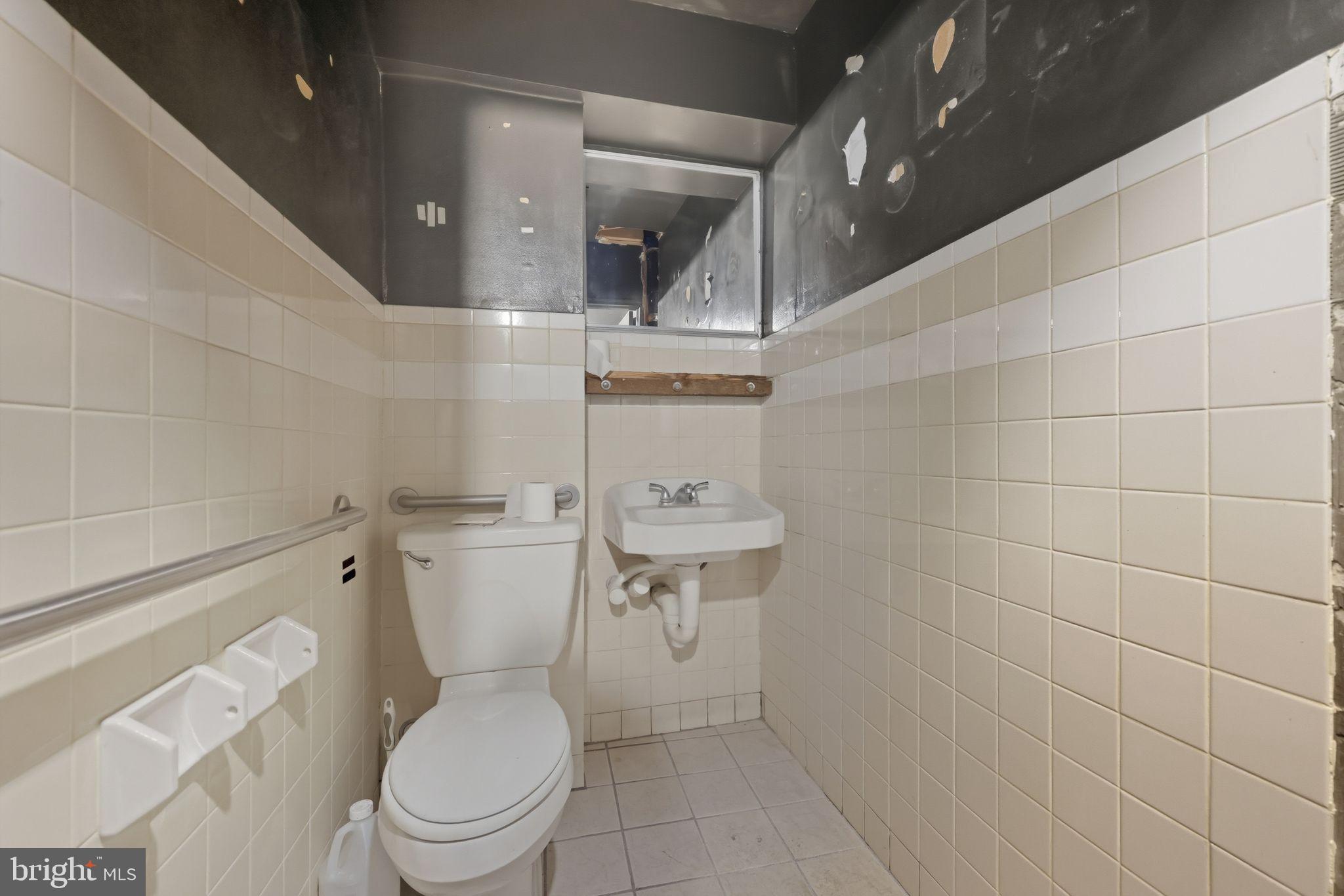 1713 South Street Philadelphia, PA 19146 - Photo 26 of 35 a white toilet sitting next to a bathroom sink and vanity