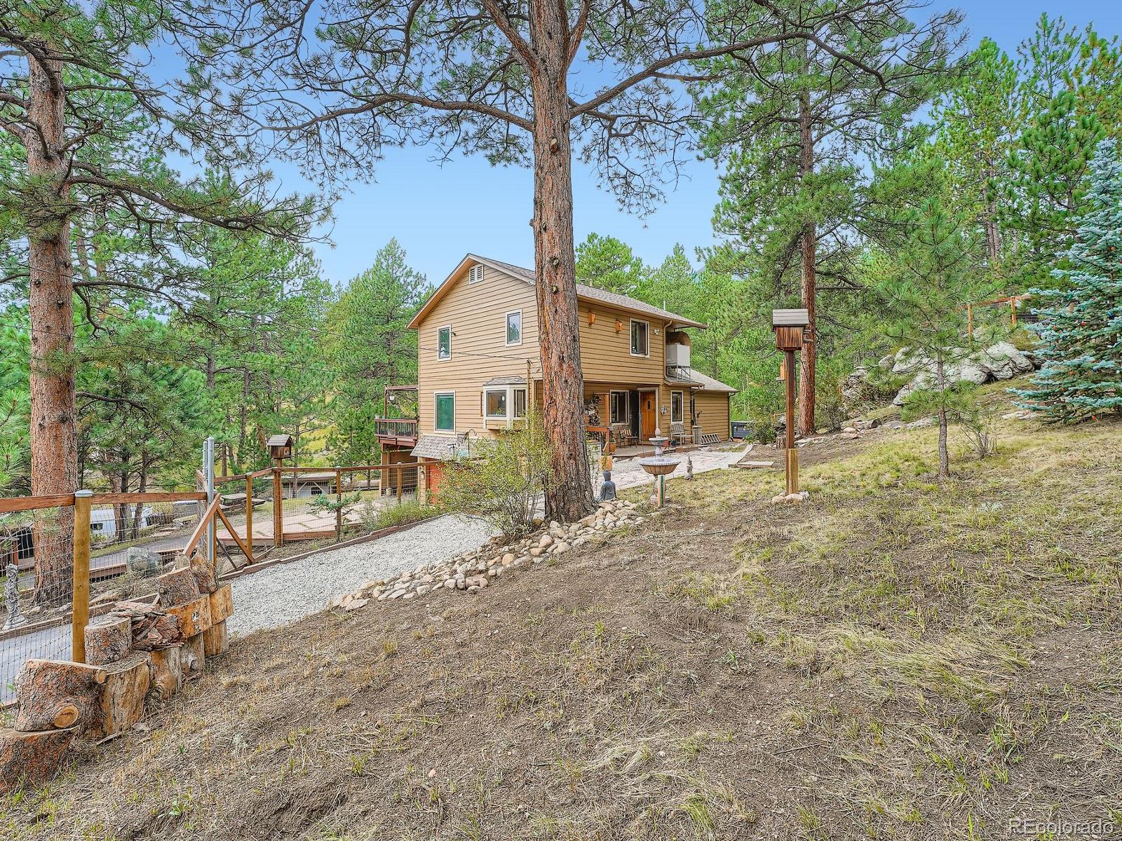 425 Patty Drive Evergreen, CO 80439 - Photo 2 of 43 a view of a house with a yard and large tree