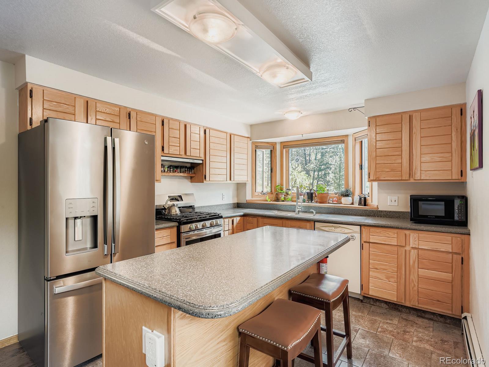 425 Patty Drive Evergreen, CO 80439 - Photo 10 of 43 a kitchen with granite countertop a refrigerator stove microwave and sink