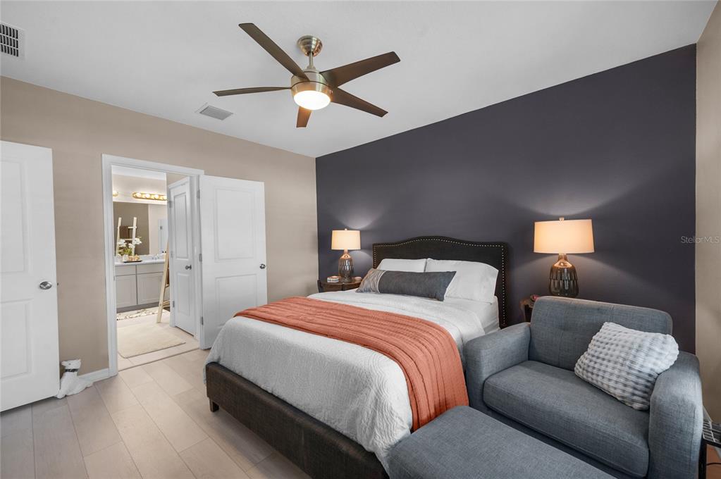 6236 Springmont Loop Palmetto, FL 34221 - Photo 18 of 55 a spacious bedroom with a bed and a chandelier