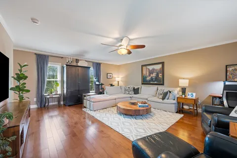 a living room with furniture and a wooden floor