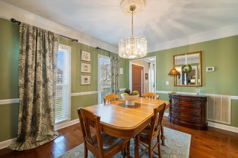 a view of a dining room with furniture wooden floor and chandelier