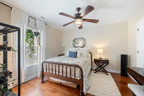 a bedroom with a bed a chandelier and a dresser