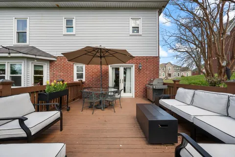 a view of a patio with couches and table and chairs under an umbrella