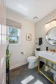 a bathroom with a toilet sink and mirror