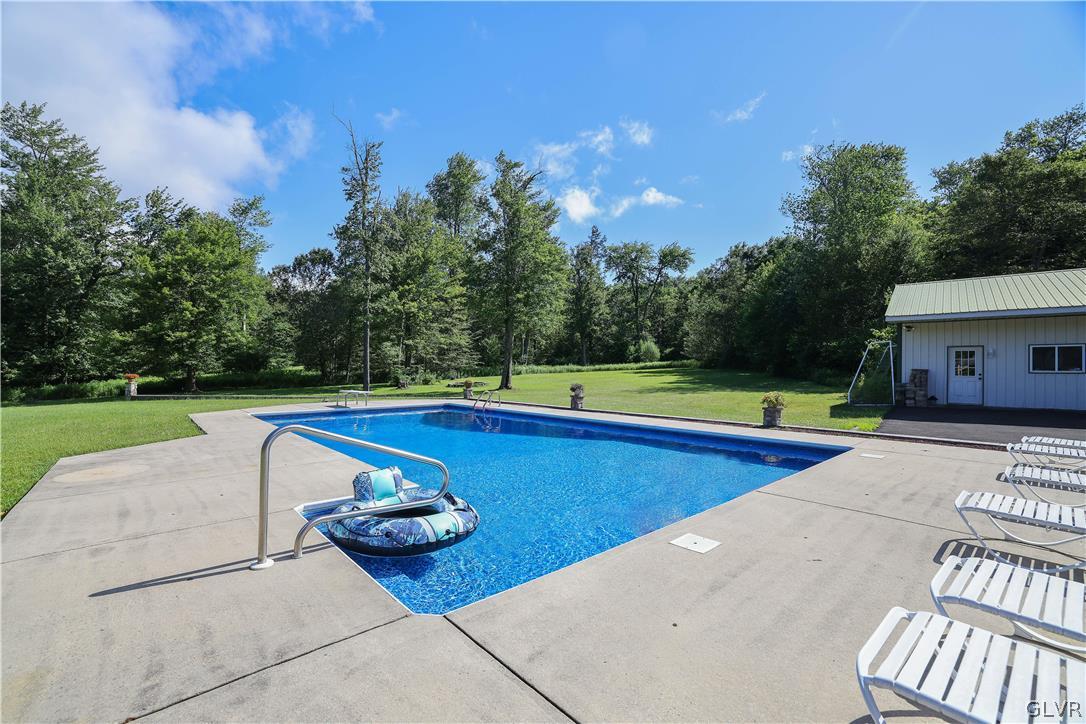 2285 Green Road Tobyhanna, PA 18466 - Photo 36 of 42 a view of swimming pool with lounge chair and trees in the background