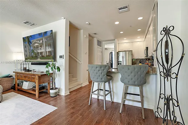 a kitchen with stainless steel appliances granite countertop a refrigerator and a stove top oven