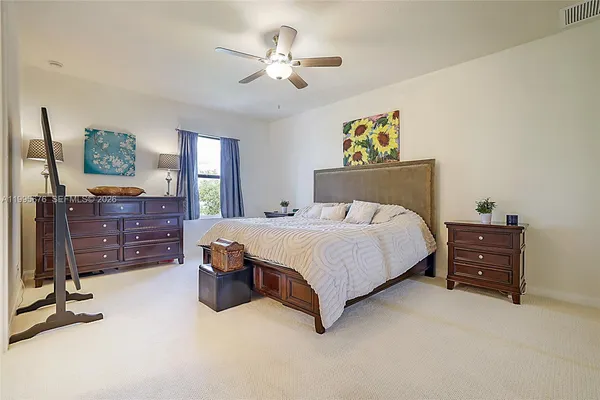 a bedroom with a bed and painting on the wall