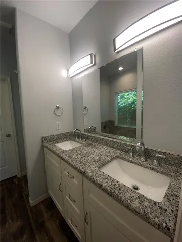 a bathroom with a granite countertop sink and a mirror