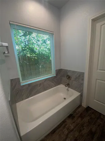a bathroom with a bathtub and window