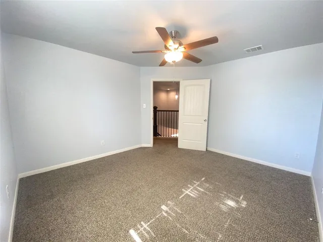 a view of an empty room with a chandelier fan