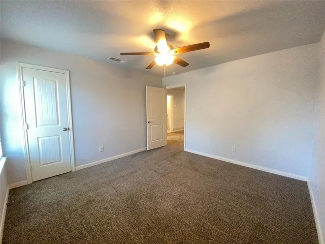 an empty room with closet and a chandelier fan