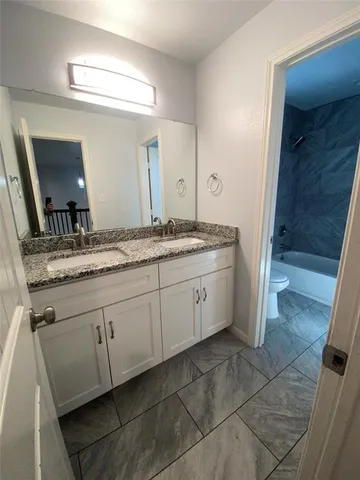 a spacious bathroom with a granite countertop sink a mirror and a