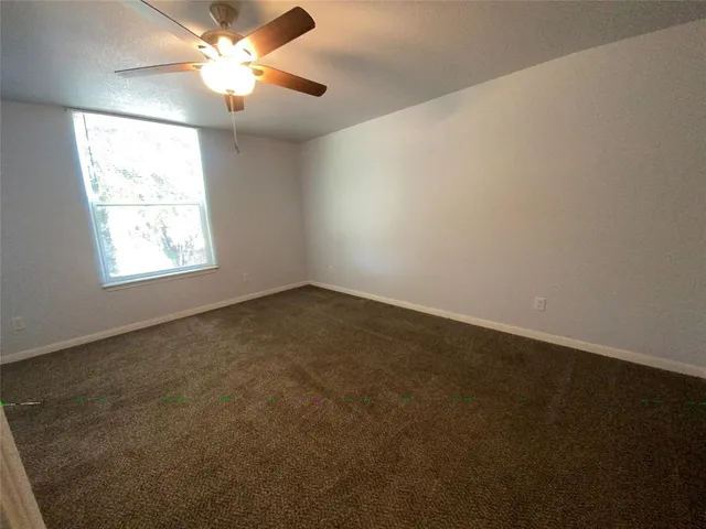 an empty room with fan and windows