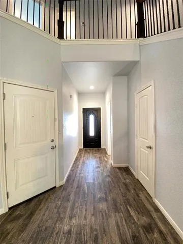 a view of a hallway with wooden floor and staircase
