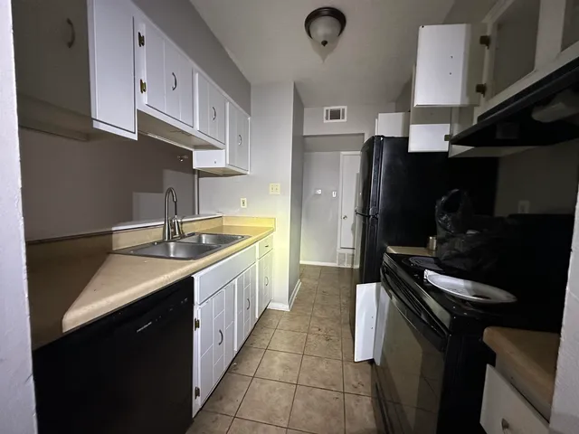 a kitchen with a sink appliances and cabinets