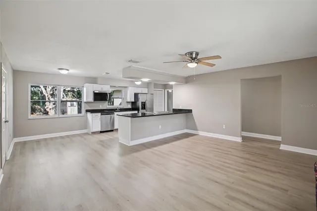a view of kitchen with sink microwave and stove top oven