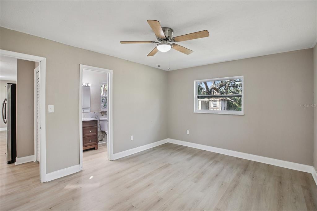 204 East Shell Point Road Ruskin, FL 33570 - Photo 20 of 48 an empty room with wooden floor ceiling fan and windows
