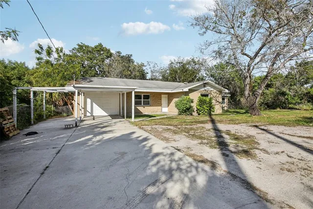 a view of a house with backyard and trees