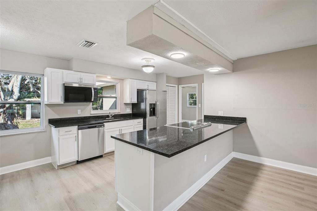 204 East Shell Point Road Ruskin, FL 33570 - Photo 7 of 48 a kitchen with stainless steel appliances granite countertop a sink a stove top oven a counter space and cabinets