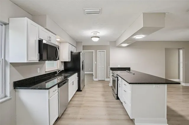 a kitchen with granite countertop a stove and a sink